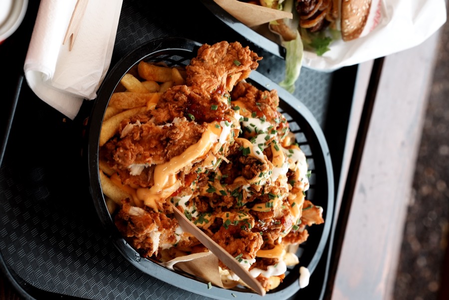 Loaded Fries und Burger auf dem Tisch